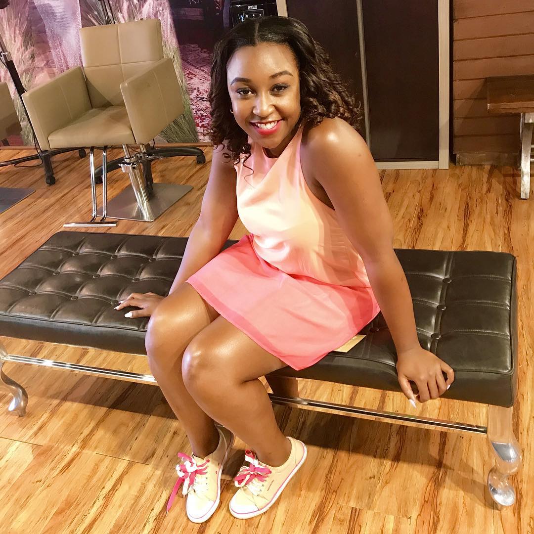 Betty Kyallo sitting on chair in pink