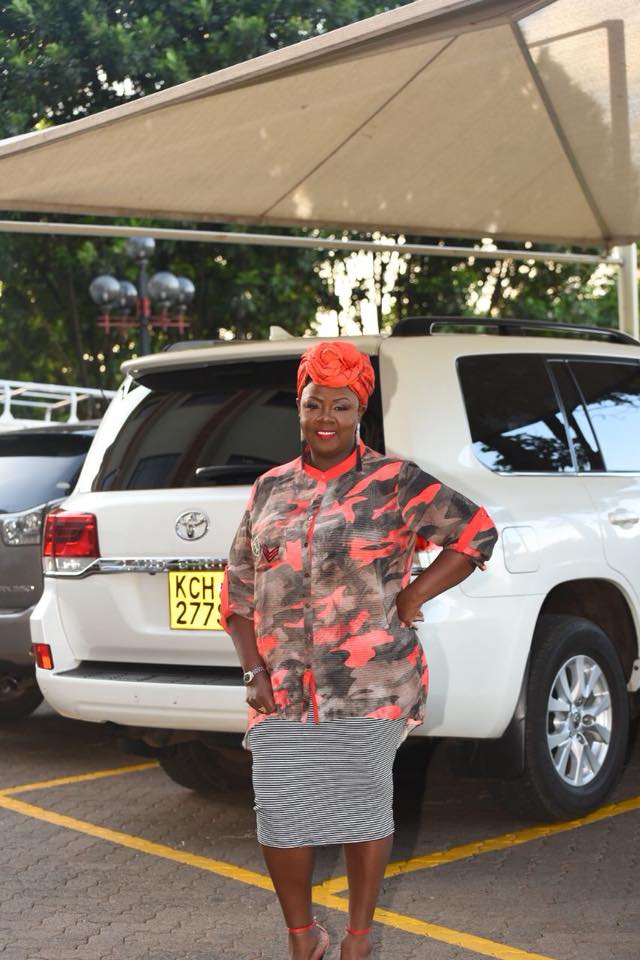Kathy Kiuna in front of expensive car