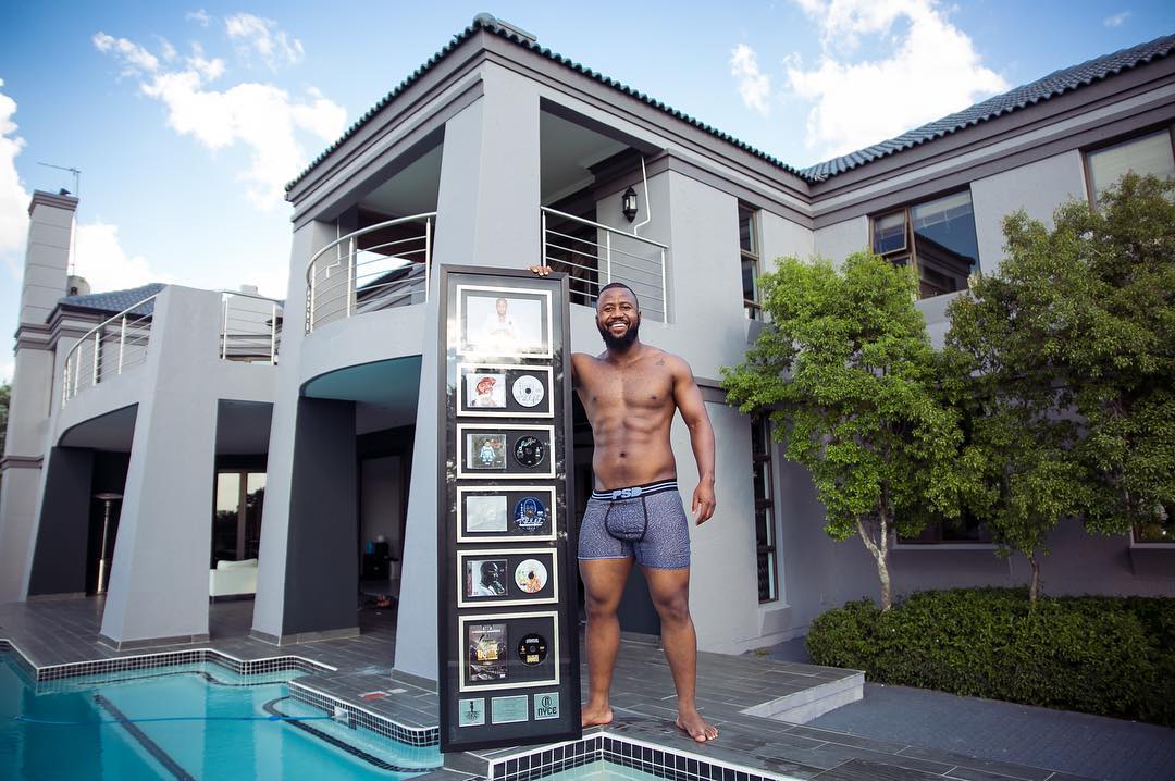Cassper Nyovest showing off his records that sold cumulatively 10 million