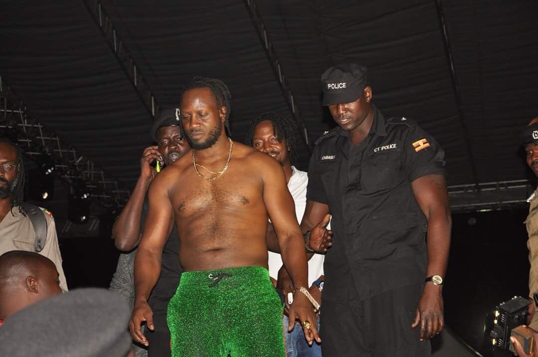 police escorts musician Bebe Cool off stage.