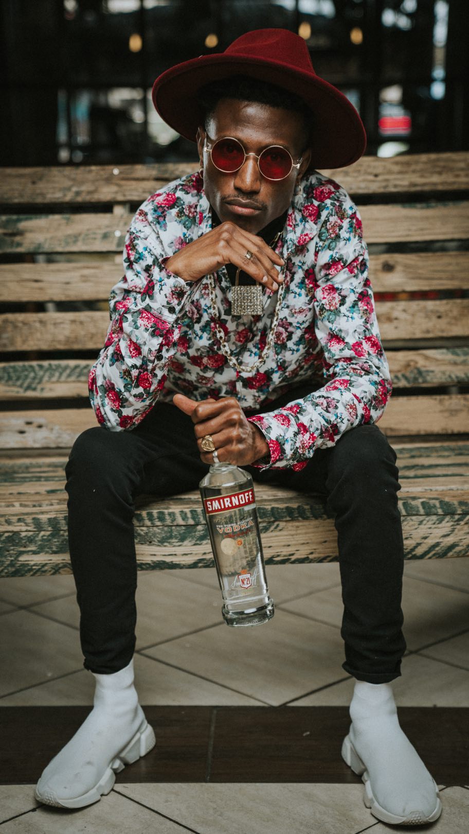 Octopizzo photo shoot as the new face of Smirnoff Kenya posing with a bottle of Smirnoff. photo credit: Instagram/octopizzo