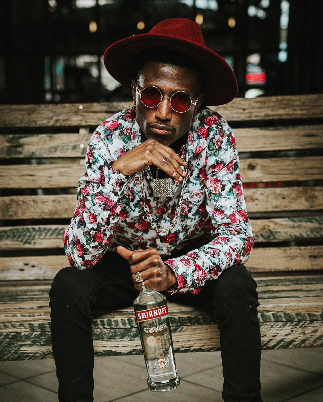 Octopizzo photo shoot as the new face of Smirnoff Kenya posing with a bottle of Smirnoff. photo credit: Instagram/octopizzo