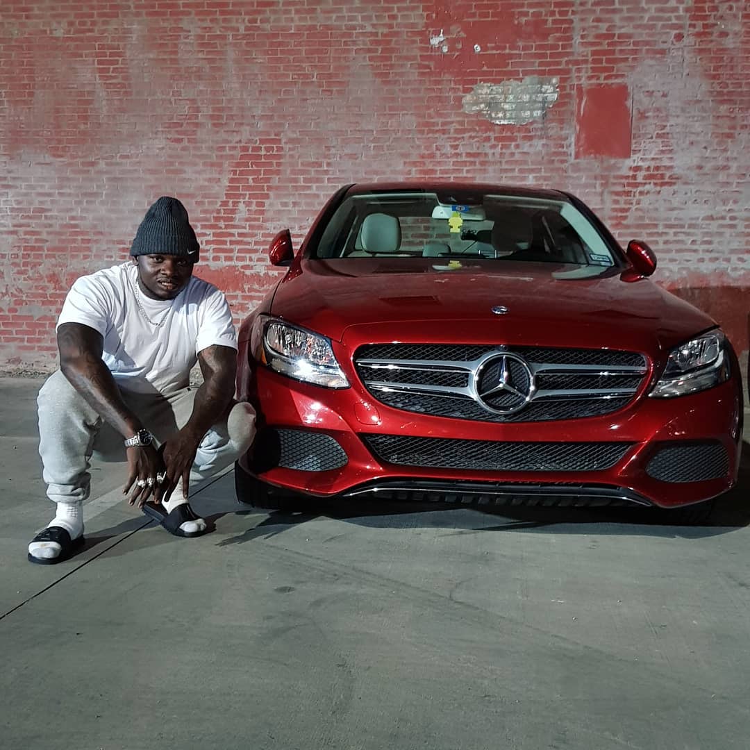 Khaligraph Jones in front of a Mercedes Benz luxury car. photo credit: Instagram/khaligraph_jones