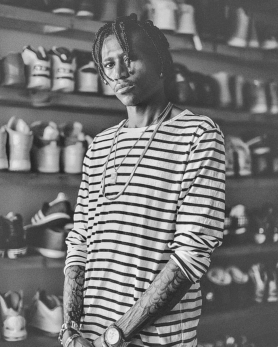 Octopizzo standing in front of his huge collection of his sneakers. photo credit: Instagram/octopizzo