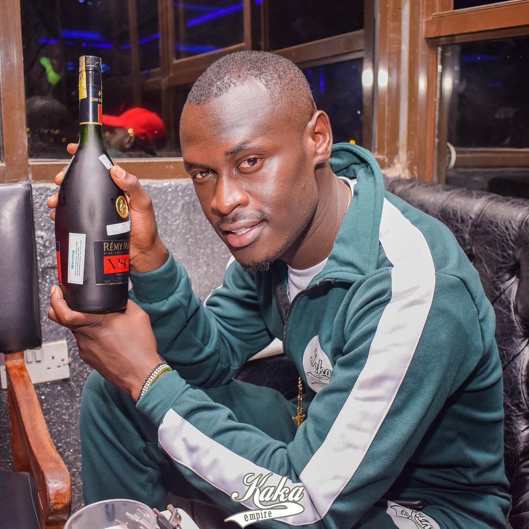 King Kaka taking a picture with a bottle of Remy Martin, he is the face and the brand ambassador for Remy Martin