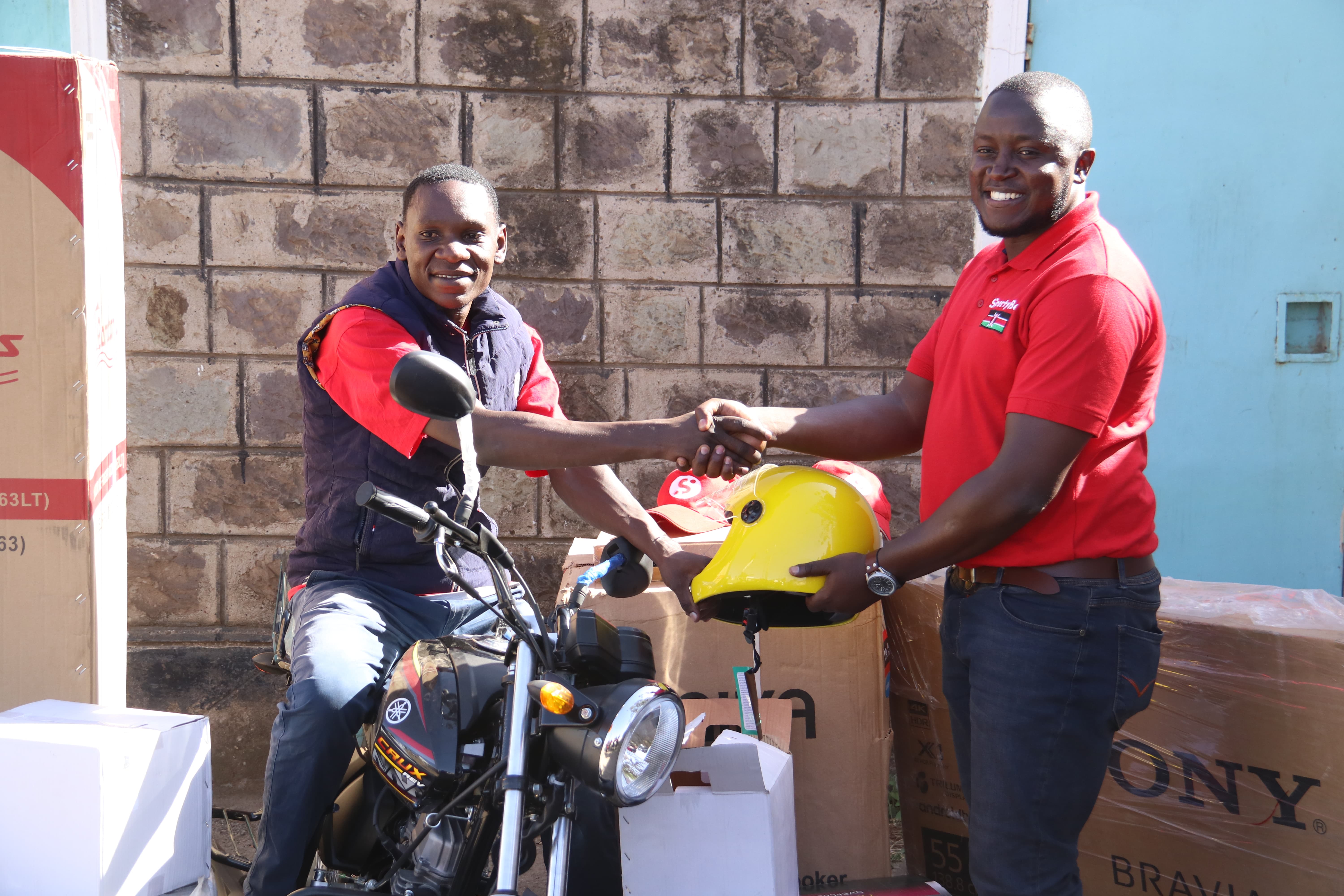 Winner Evans Onyango received the key to a motobike and other household goods from SportyBet Country Marketing Manager Steve Adundo at his Buruburu residence on Saturday 1, February 2019