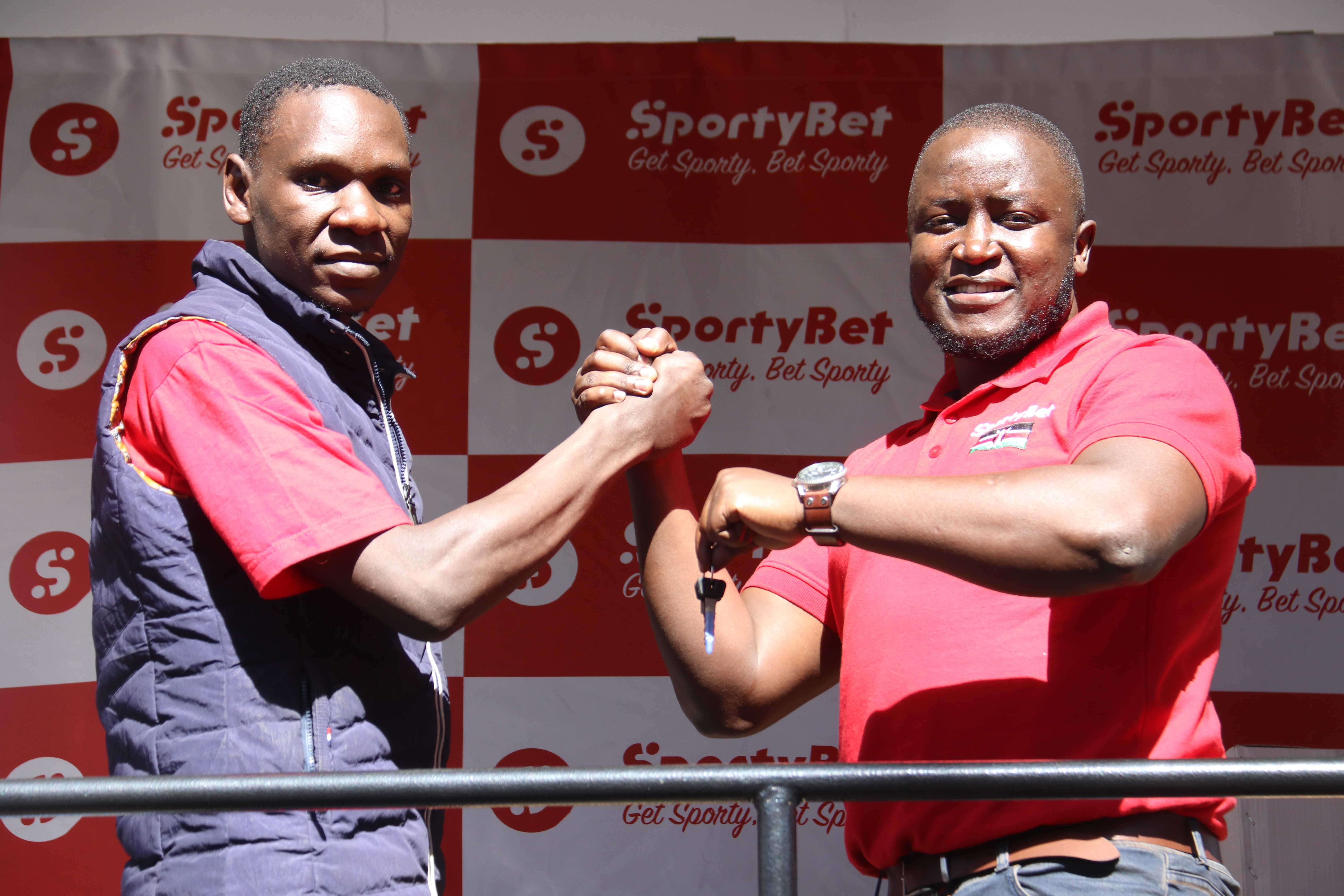 Winner Evans Onyango received the key to a motobike and other household goods from SportyBet Country Marketing Manager Steve Adundo in Buruburu on Saturday 1, February 2019-min
