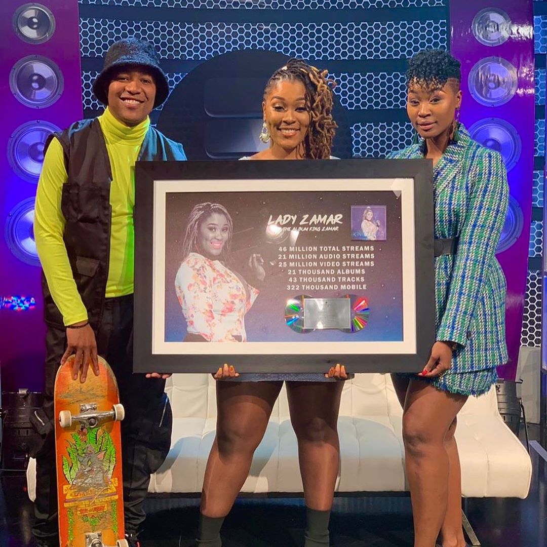 from left to right: DJ Speedsta, Lady Zamar, Dj Lamiez Holworthy holding up the 'King Zamar' double platinum plaque on the Live Amp show. photo credit: Instagram/lady_zamar