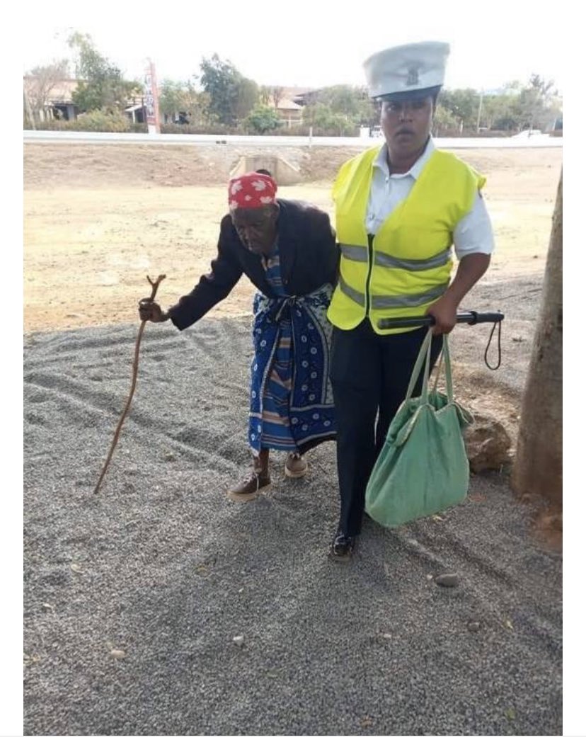 Police Officer, AMina Mutio helping out an elderly woman a few years ago prior to her helping out a mother in Utawala. Photo credit: Facebook