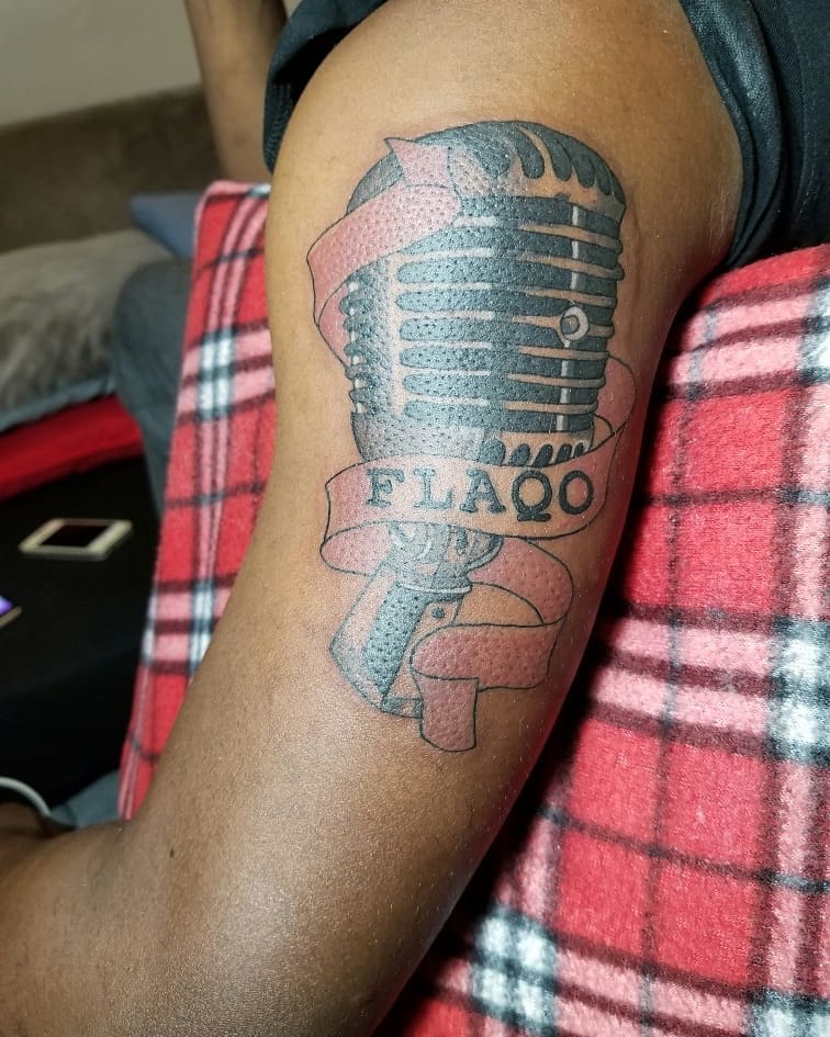 Flaqo Raz's upper arm microphone tattoo. Photo credit: Instagram/kinginktattoos_johnfabianor