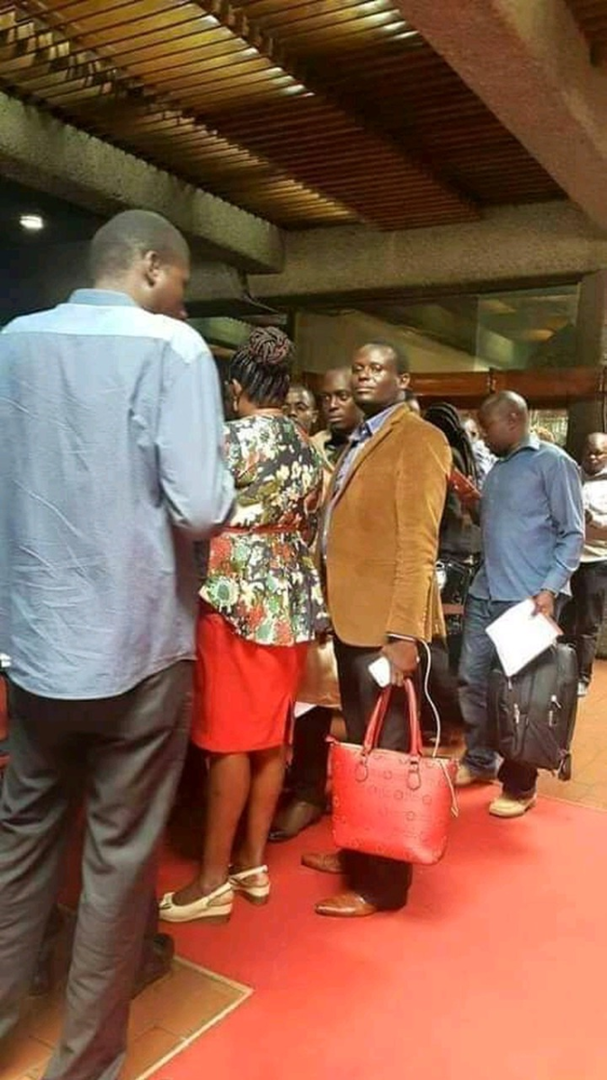 Musician Murega Baichu carrying his wife's Governor Kawira Mwangaza's handbag